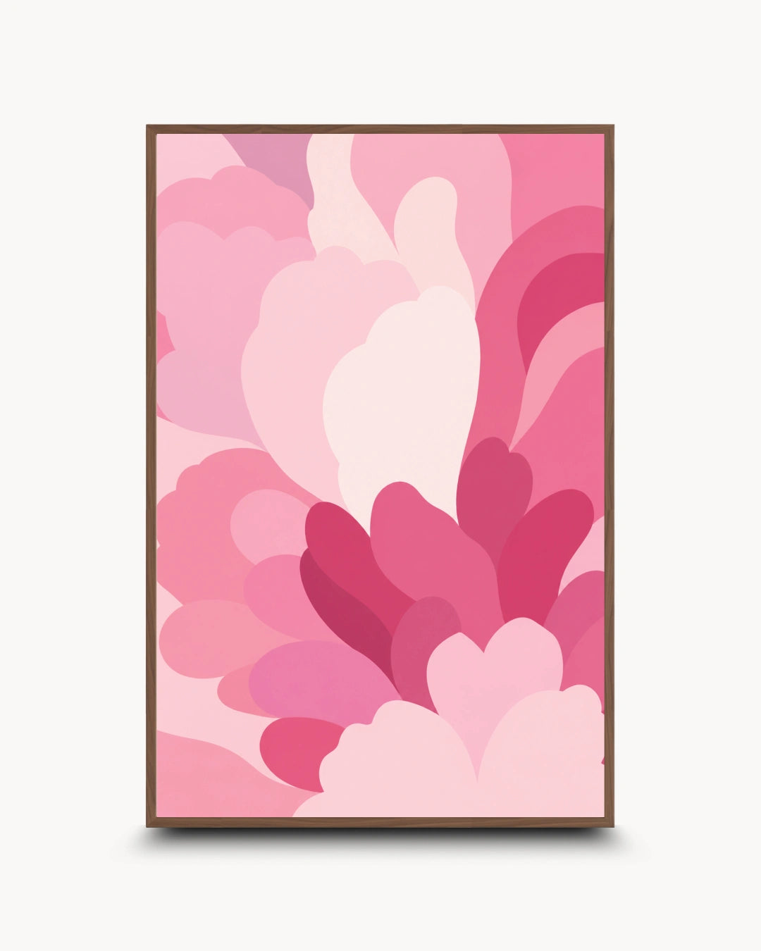 A framed abstract art print featuring layered, organic pink shapes in various shades of light, medium, and deep pink, enclosed in a thin black frame against a light gray background.