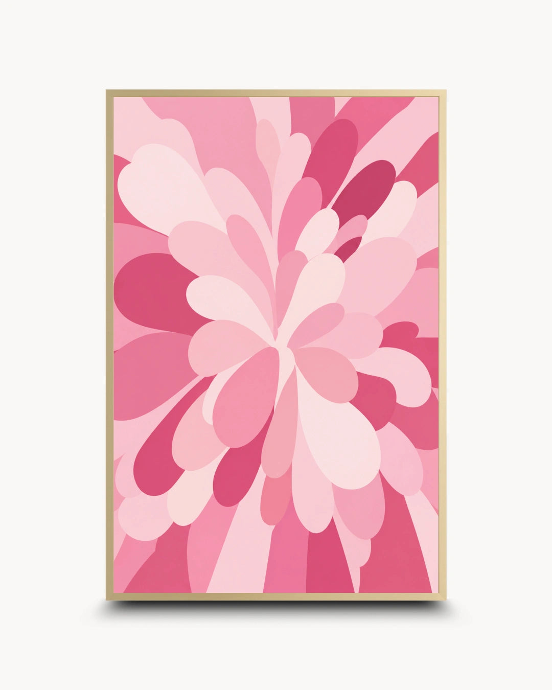 A framed abstract floral art print featuring layered petal-like shapes in various shades of pink, with a light wood frame, shown against a clean off-white background.