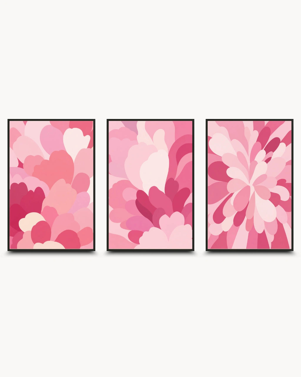 A three-piece framed wall art set featuring abstract floral and petal-like patterns in various shades of pink, with thin black frames, displayed against a light off-white background.