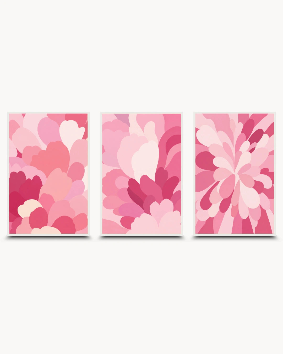 Three vertical framed wall art panels with abstract floral and petal-like shapes in shades of pink, coral, and magenta on a light gray background.