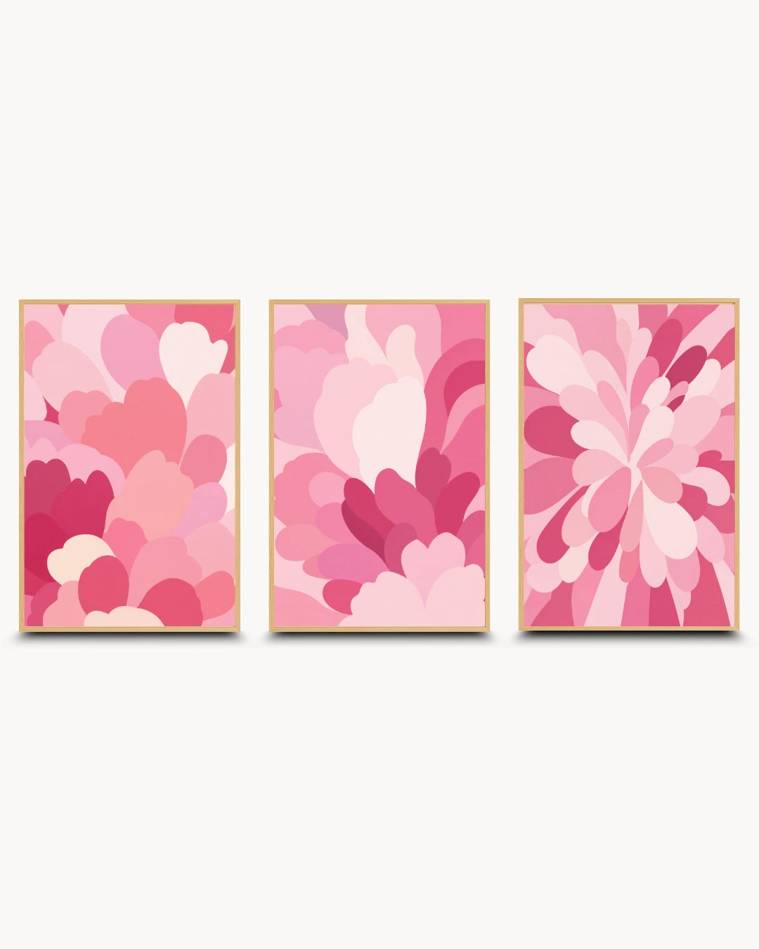 Three framed abstract floral wall art prints in shades of pink, arranged side by side on a light gray background.