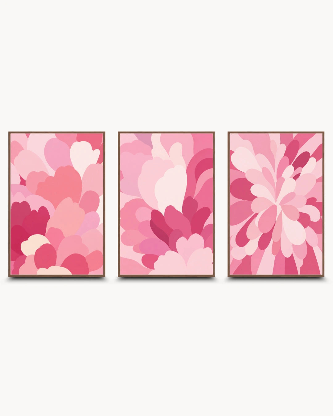 Three framed abstract floral wall art prints in shades of pink, arranged side by side on a light gray background.