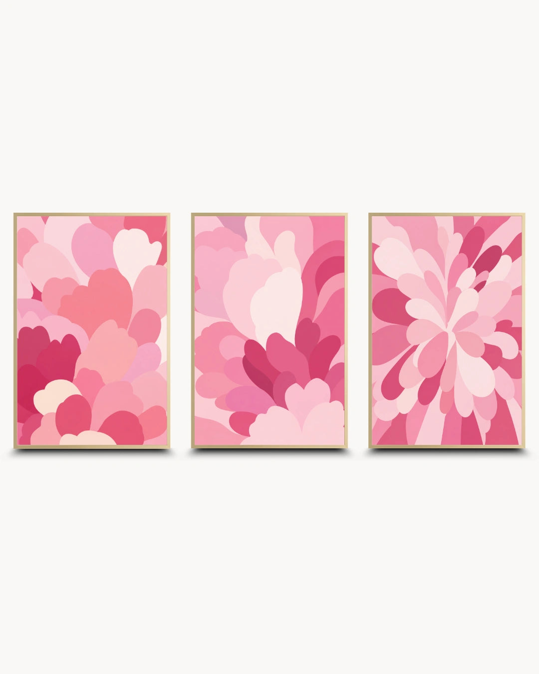 Three framed abstract floral wall art prints in shades of pink, arranged side by side on a light gray background.