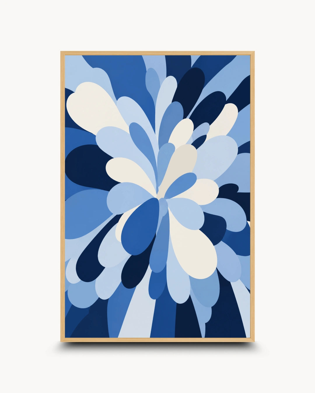 A framed abstract floral art print featuring layered blue and white petal-like shapes, enclosed in a light wood frame against a clean off-white background.