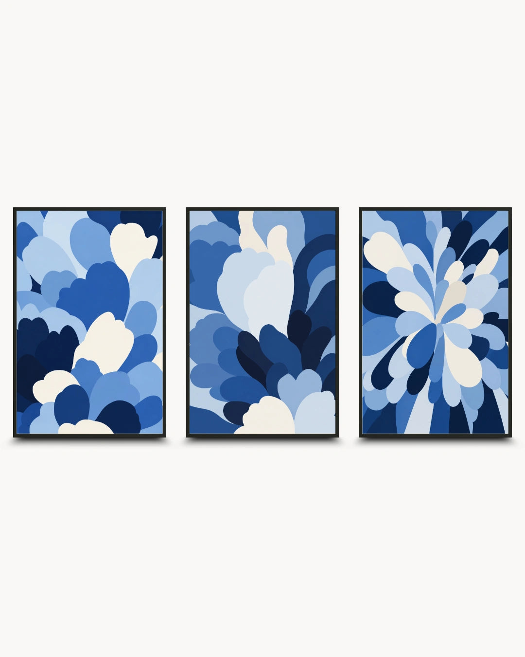 A three-piece framed wall art set featuring abstract blue and white floral-like shapes on a light gray background.