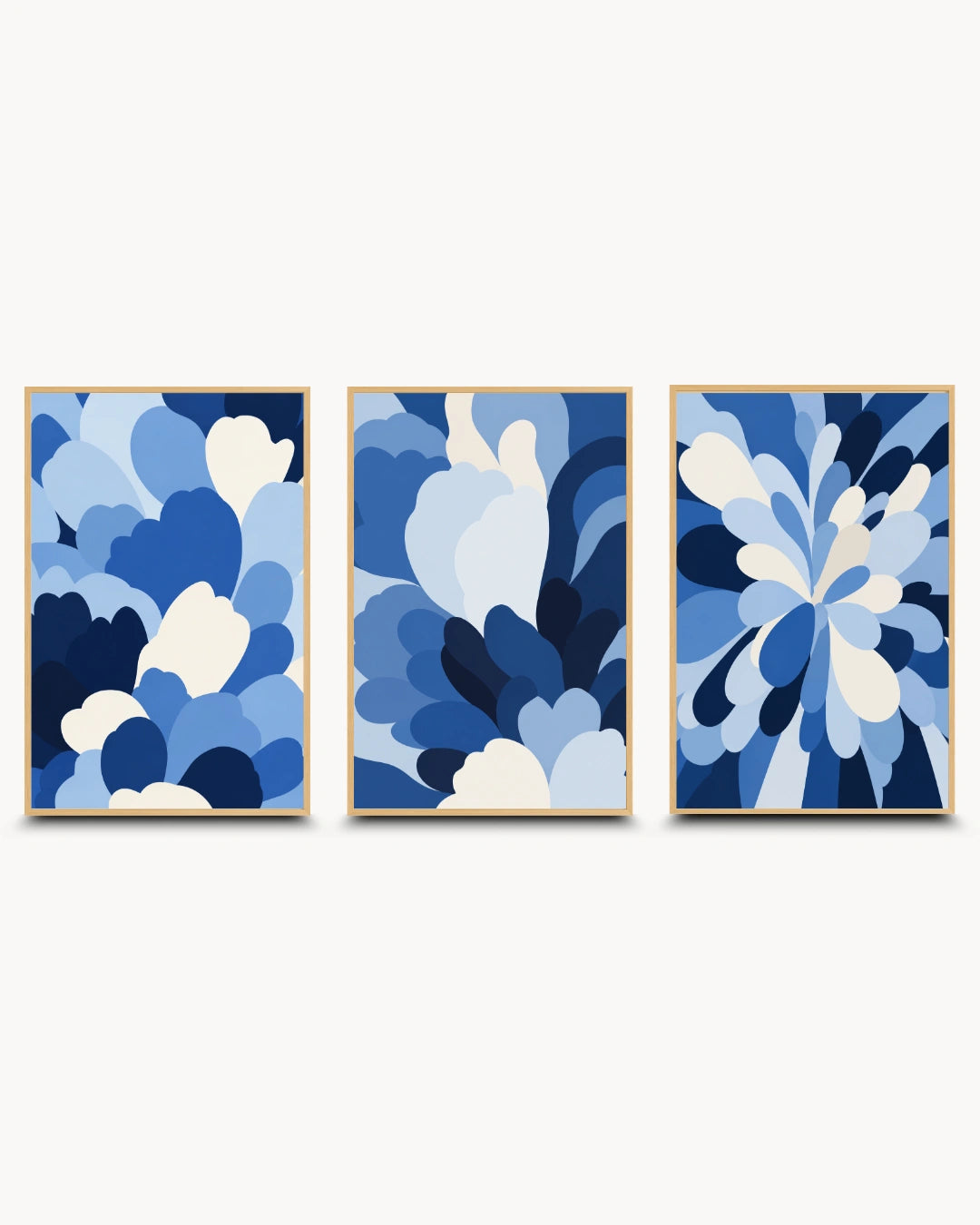Three framed abstract floral wall art prints in shades of blue and white, arranged side by side on a light gray background.