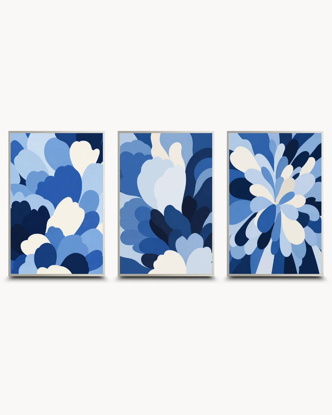 A three-piece framed wall art set featuring abstract blue and white floral or cloud-like patterns on a light gray background.