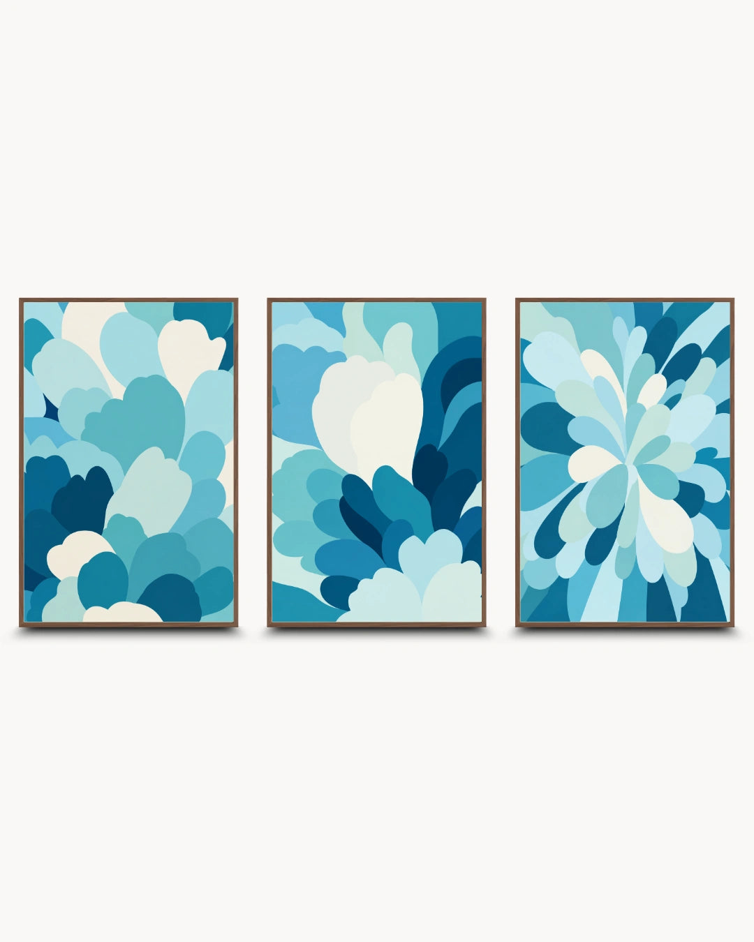 Three framed abstract wall art prints with layered blue and white petal-like shapes, arranged side by side on a light gray background.