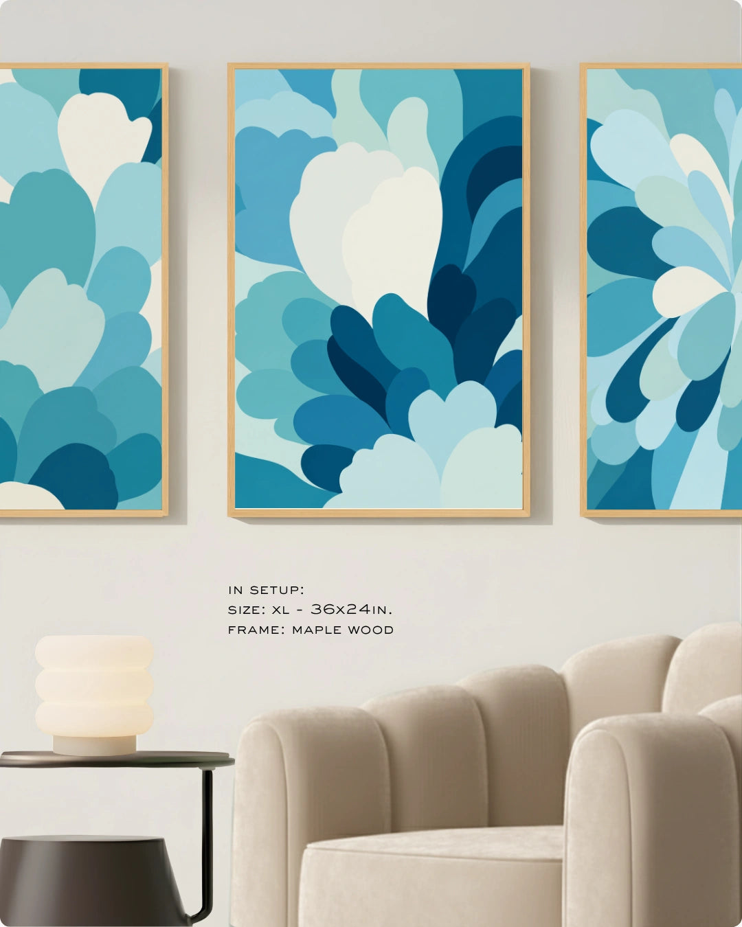 Three framed abstract wall art prints with layered blue and white floral-like shapes, displayed above a beige armchair in a styled interior. Text reads: 'IN SETUP: SIZE: XL - 36x24in.