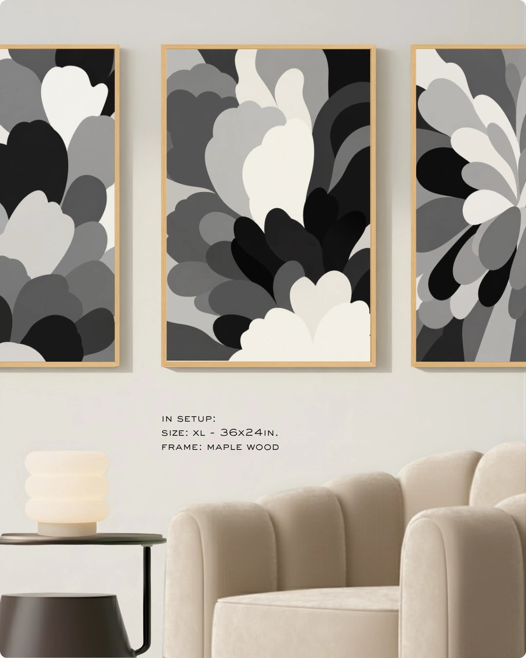 Three framed abstract wall art prints in black, white, and gray floral shapes, displayed in a living room setup above a beige armchair and side table. Text on the image reads: 'IN SETUP: SIZE: XL - 36x24in.