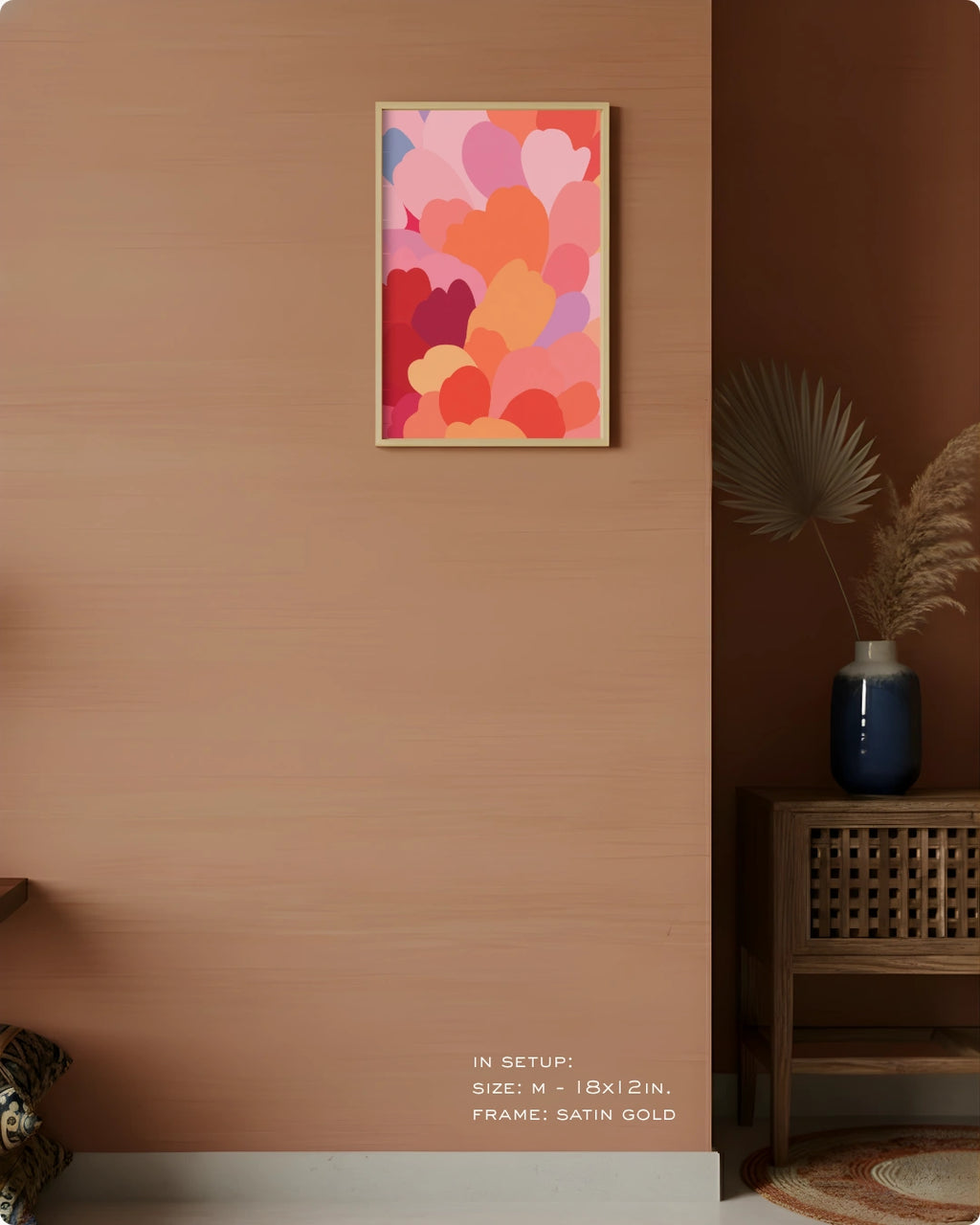 A framed abstract art print with overlapping colorful hearts in pink, red, orange, and purple, displayed on a warm brown wall in a styled interior setting.
