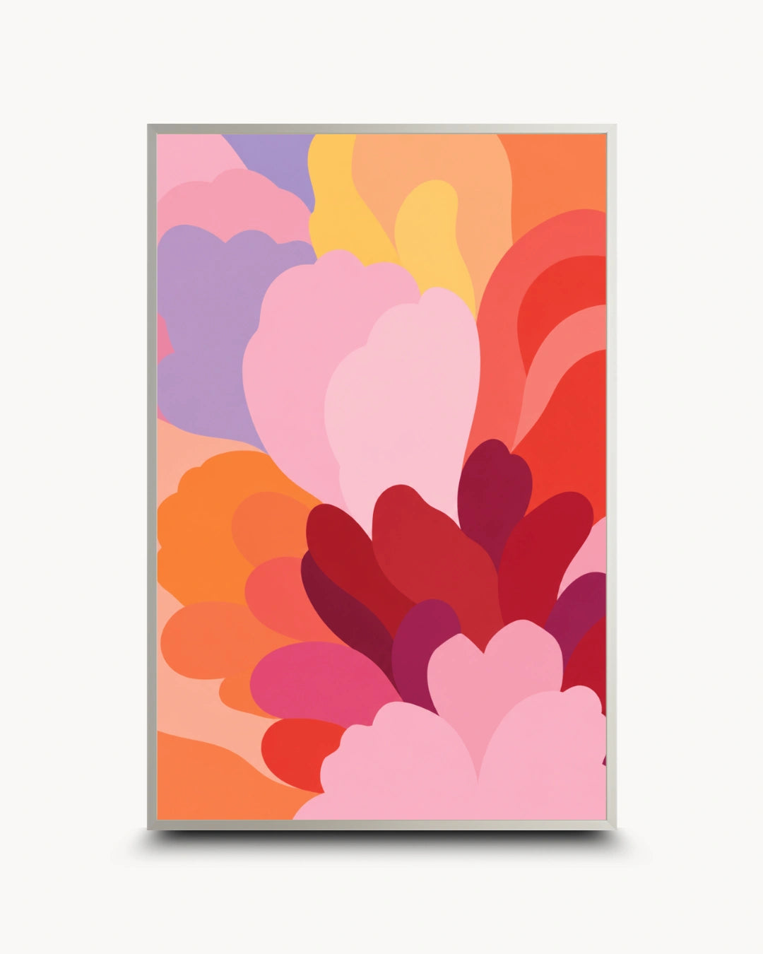 A framed abstract art print featuring layered, organic petal-like shapes in pink, red, orange, yellow, and purple, displayed against a clean off-white background.