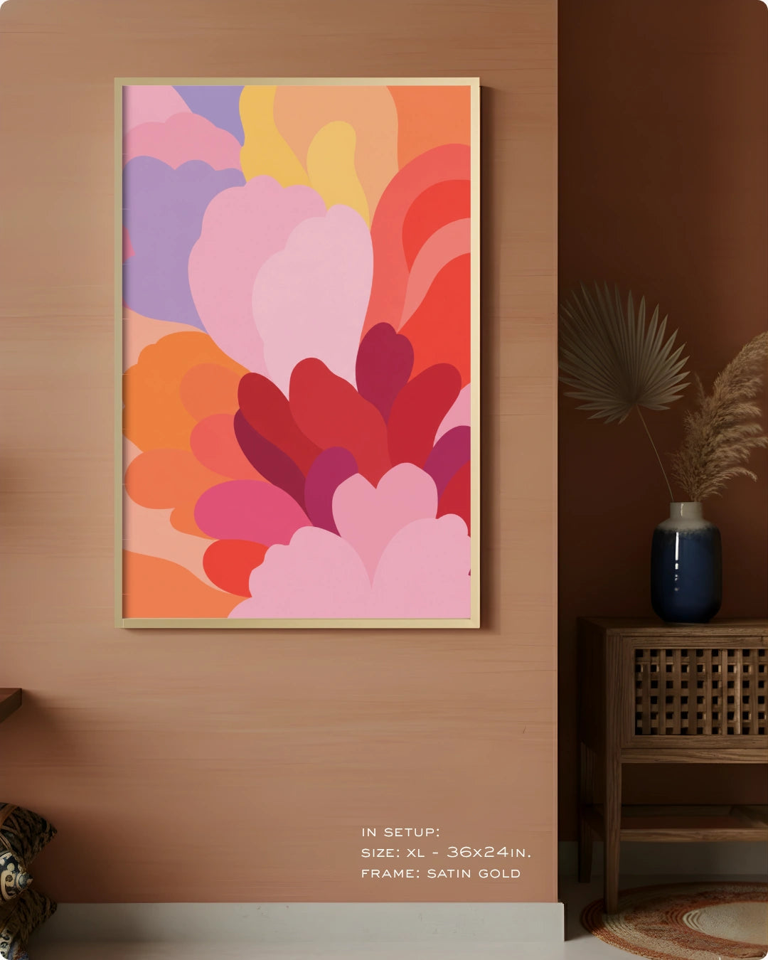 A framed abstract floral wall art print with layered pink, red, orange, yellow, and purple shapes, displayed on a warm wood wall in a styled interior setting.