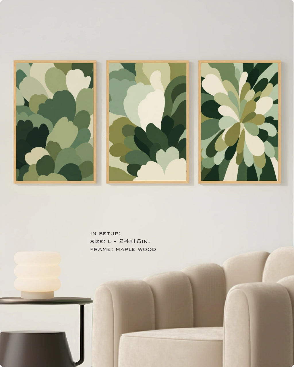 Three framed abstract botanical wall art prints in shades of green and cream are displayed on a light wall above a beige armchair, with small text noting the size and maple wood frame.