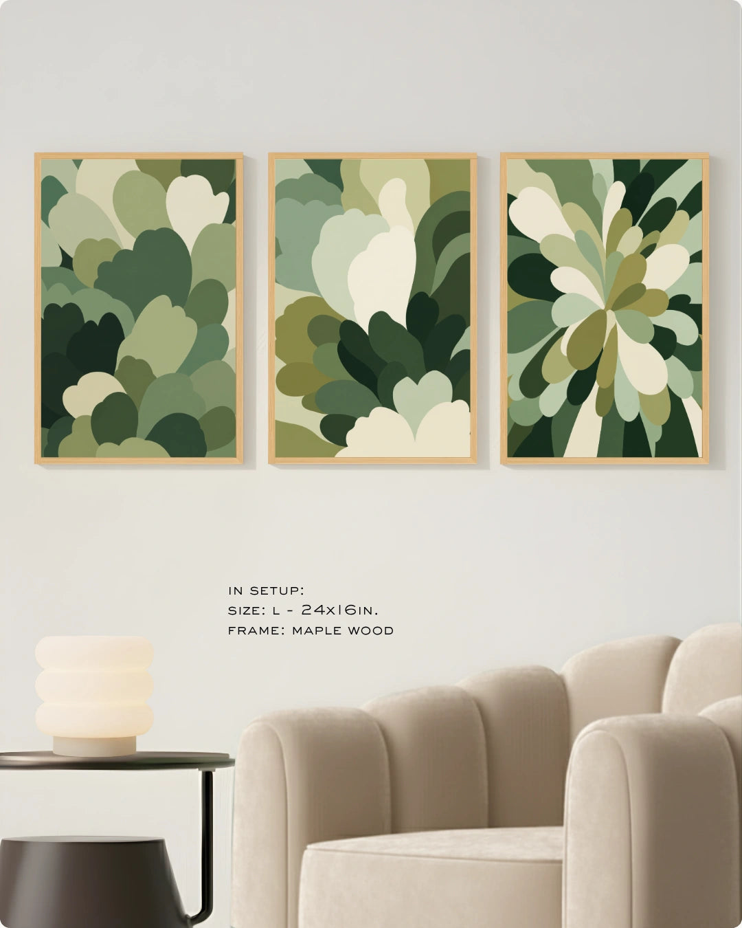Three framed abstract botanical wall art prints in shades of green and cream are displayed on a light wall above a beige armchair, with small text noting the size and maple wood frame.