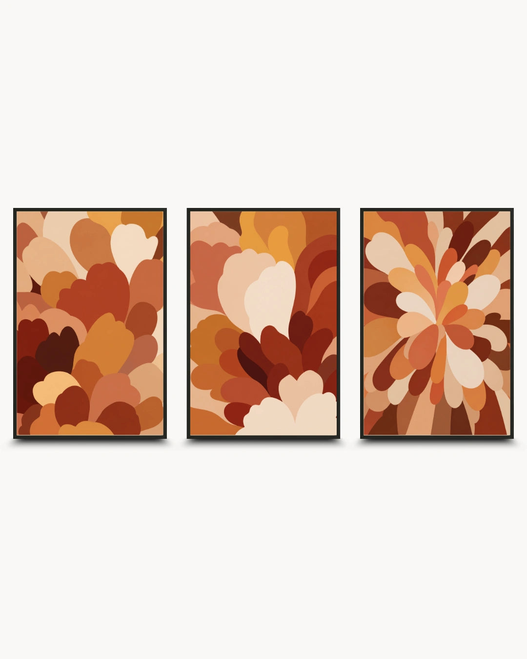 A three-piece framed wall art set featuring abstract floral and petal-like designs in warm autumn tones of brown, rust, tan, cream, and orange, displayed against a light gray background.