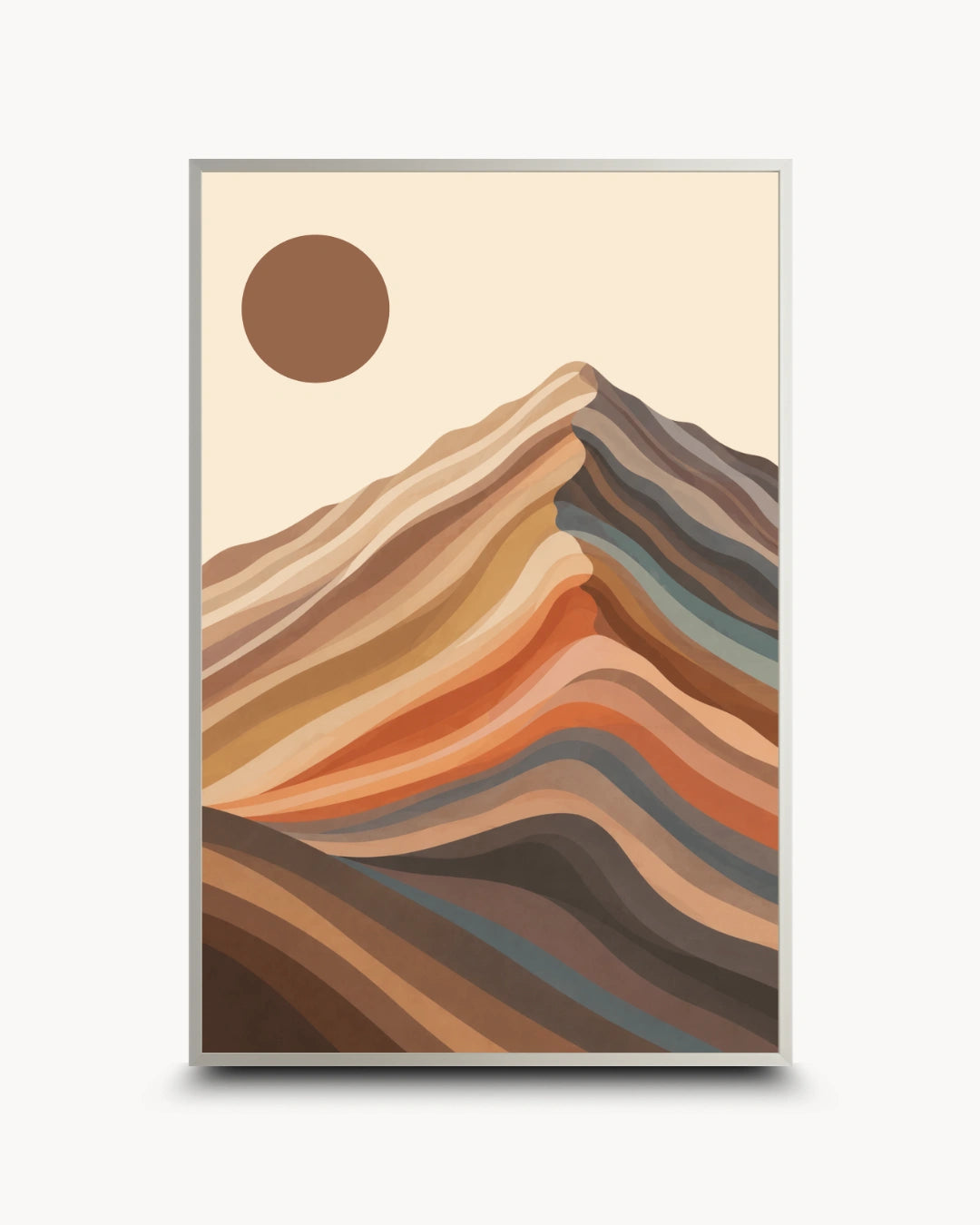 A framed minimalist art print featuring stylized layered mountain ridges in warm earth tones and a brown sun on a cream background, shown against a light gray wall.