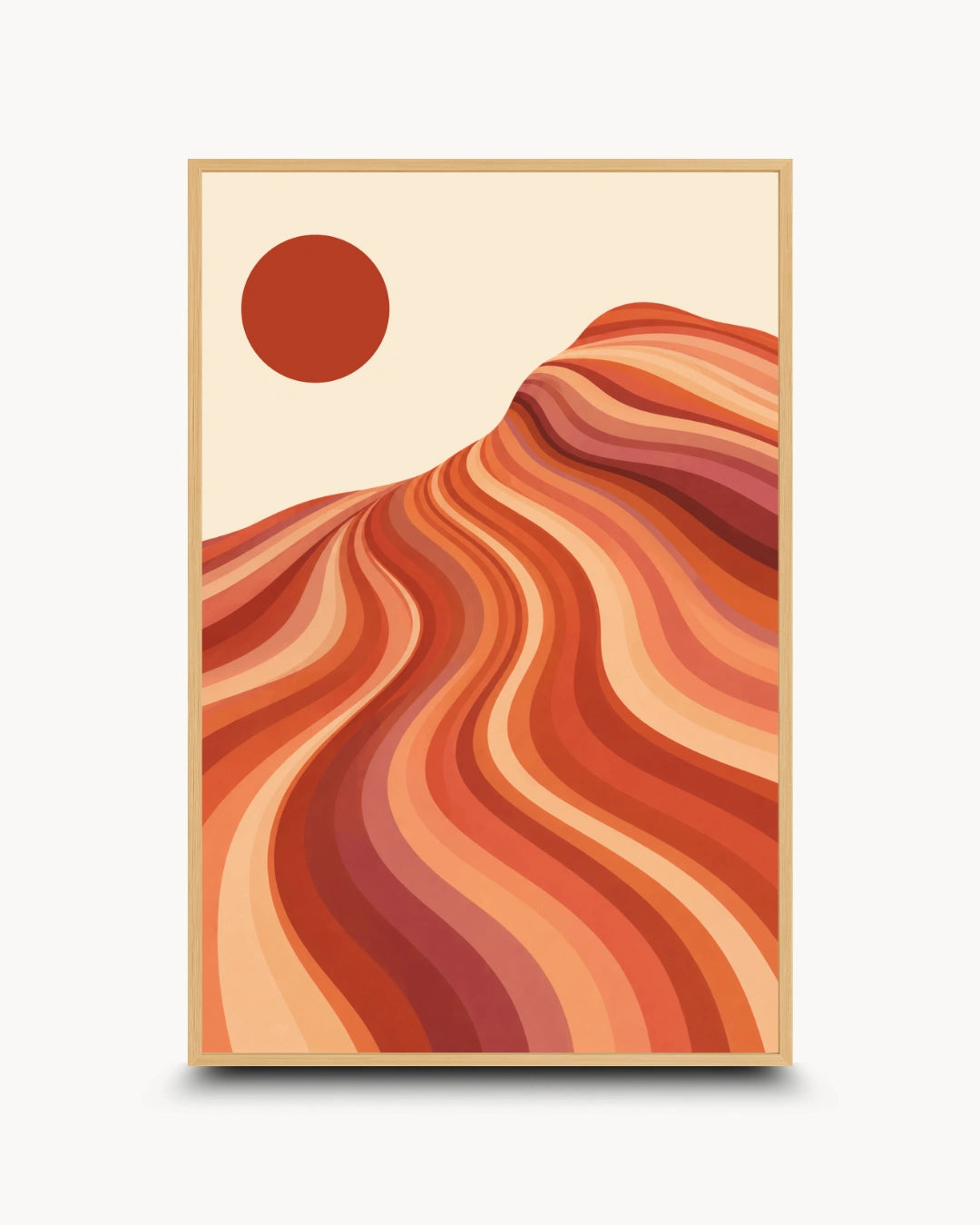 A framed art print featuring a stylized desert landscape with wavy orange and red dunes under a cream sky and a red sun, shown against a light gray background.