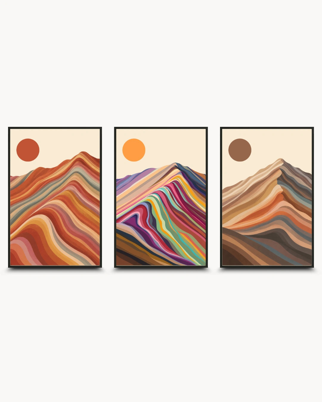 A three-piece framed wall art set featuring abstract mountain designs with colorful wavy stripes and sun motifs on a light cream background.
