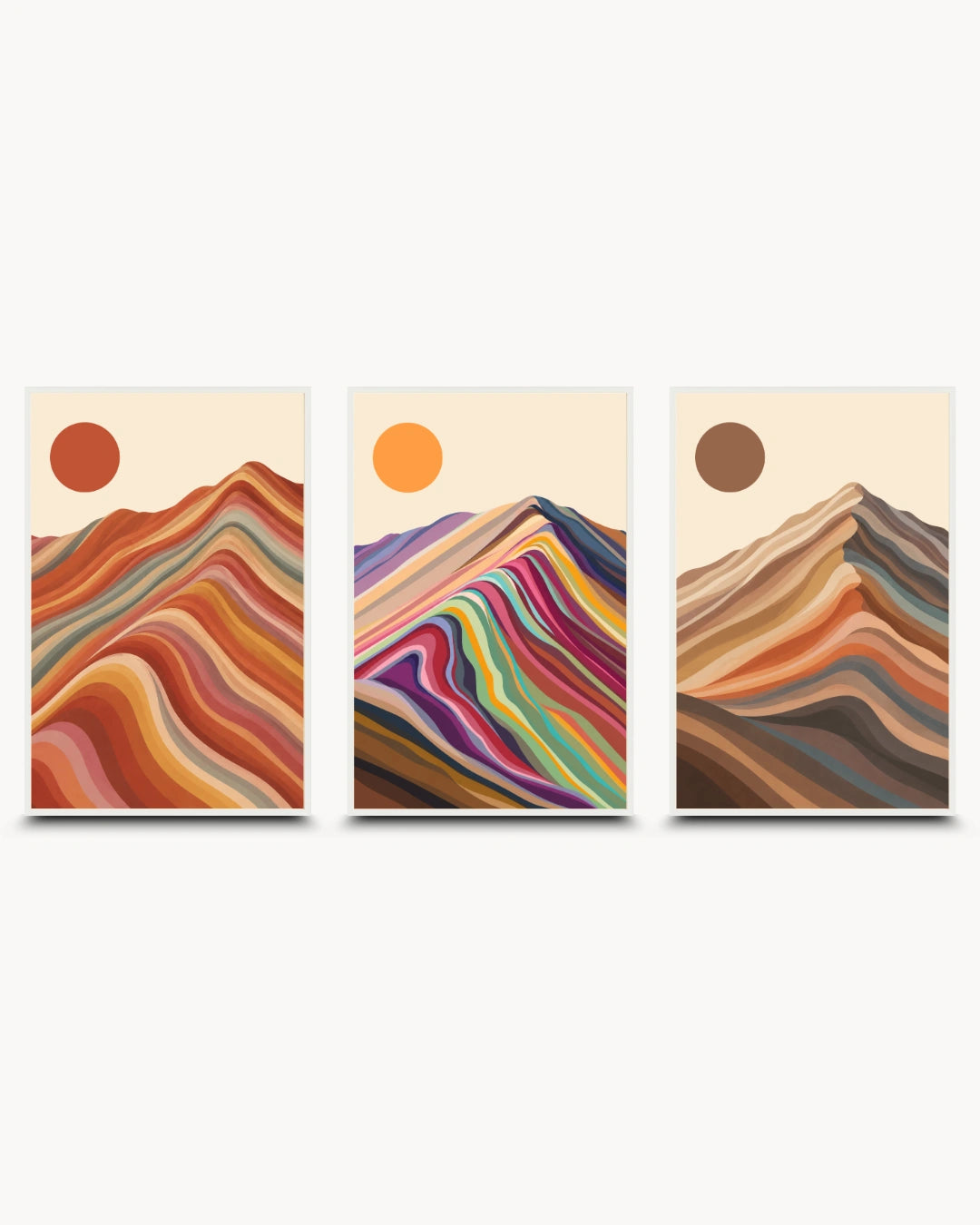 A three-piece framed wall art set featuring abstract mountain designs with colorful wavy stripes and sun motifs on a light cream background.
