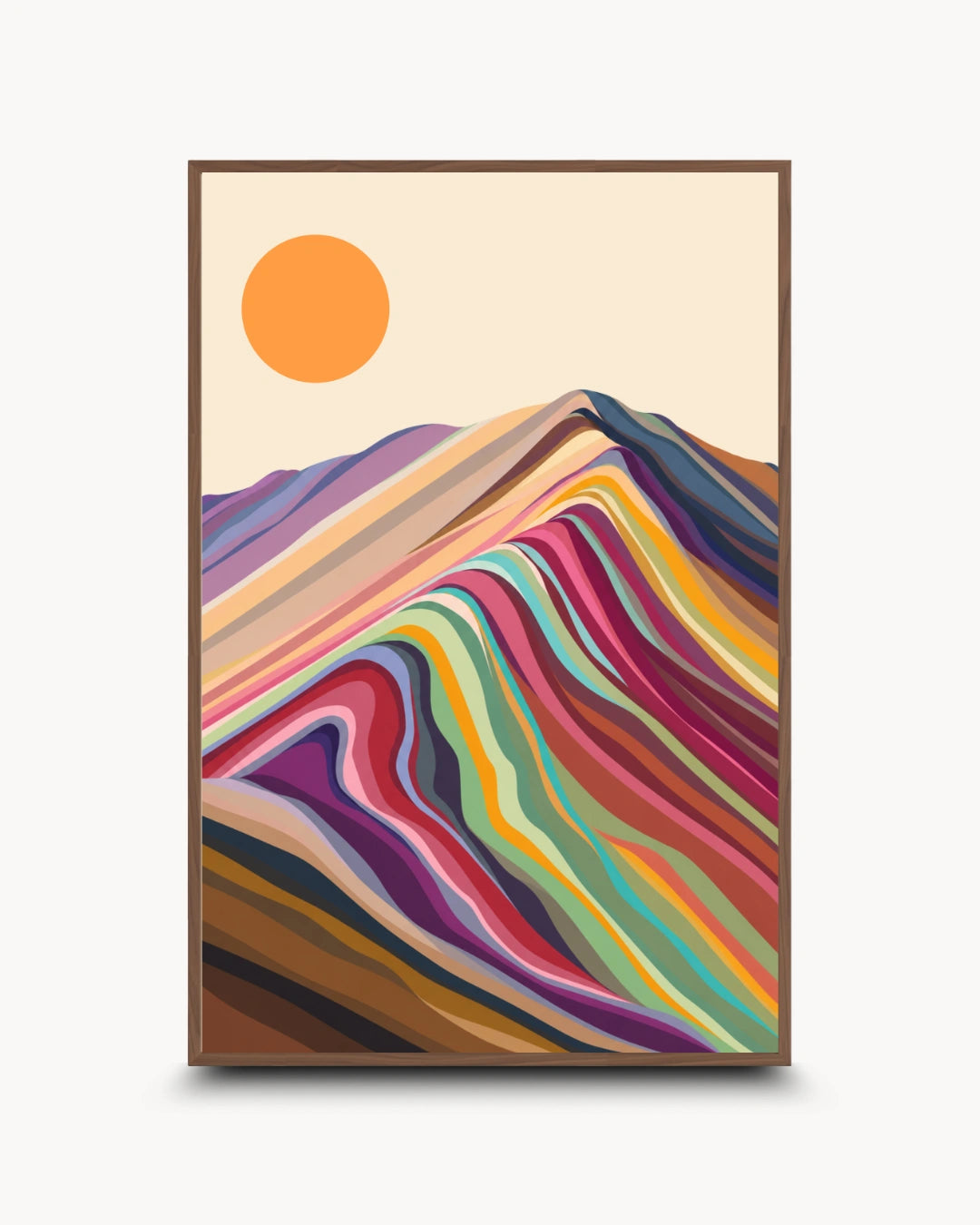 A framed art print featuring a stylized mountain landscape with layered multicolored hills and a simple orange sun on a cream background, shown against a light gray wall.