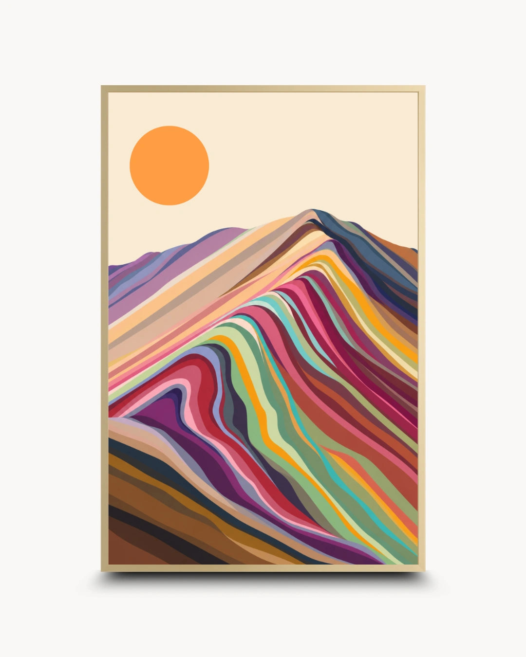 A framed art print featuring a stylized mountain landscape with layered multicolored hills and a solid orange sun on a cream background, shown against a light gray wall.