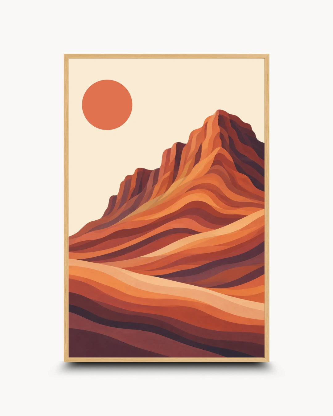 A framed art print featuring a stylized desert landscape with layered orange and brown mountains and a large orange sun on a cream background, shown against a light gray backdrop.