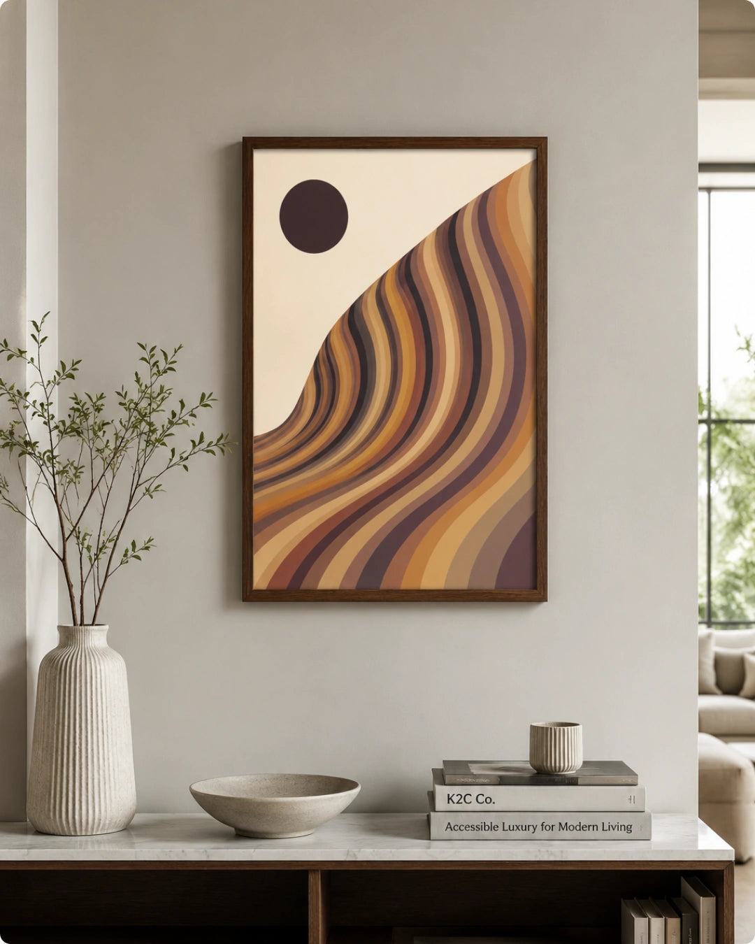 A framed abstract art print featuring wavy diagonal stripes in warm earthy tones of brown, orange, beige, and purple, hanging on a light wall above a wooden console table in a styled interior setting.