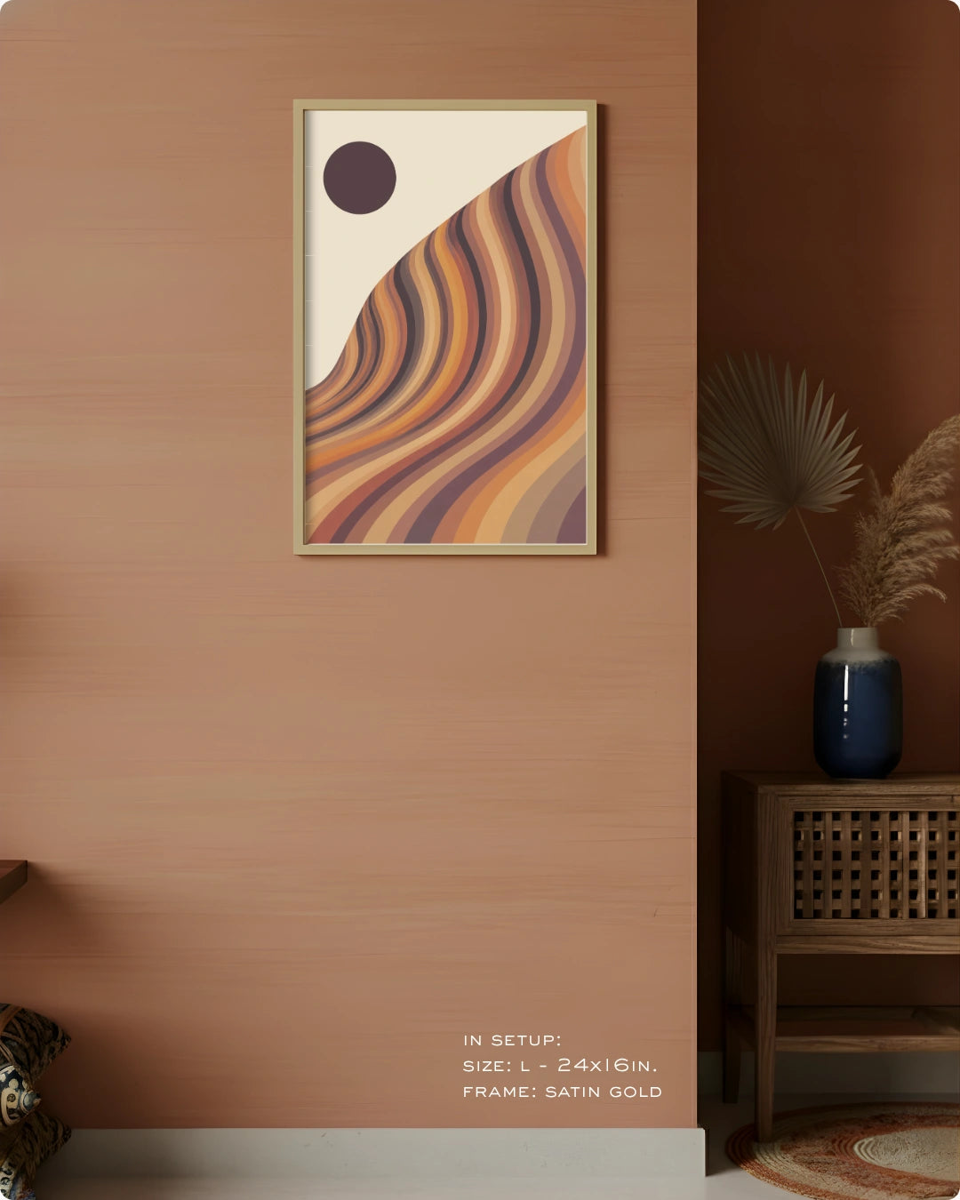 A framed abstract art print with wavy curved stripes in beige, orange, brown, and purple tones, hanging on a warm terracotta wall in a styled interior setting with a side table and vase.