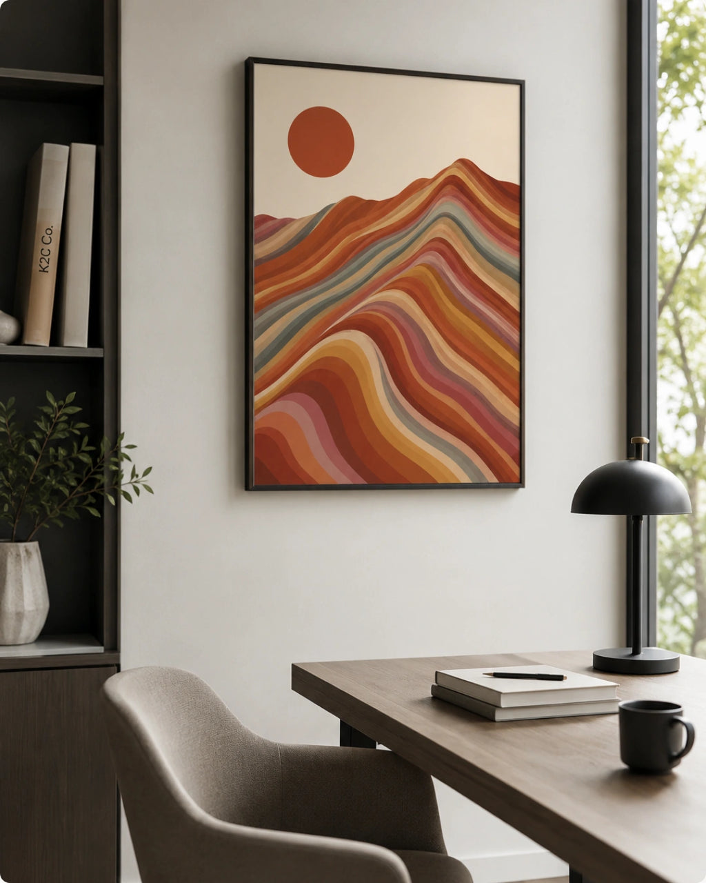 Lifestyle mockup of the landscape artwork in a black frame styled above a minimalist desk with a black lamp in a moody office.