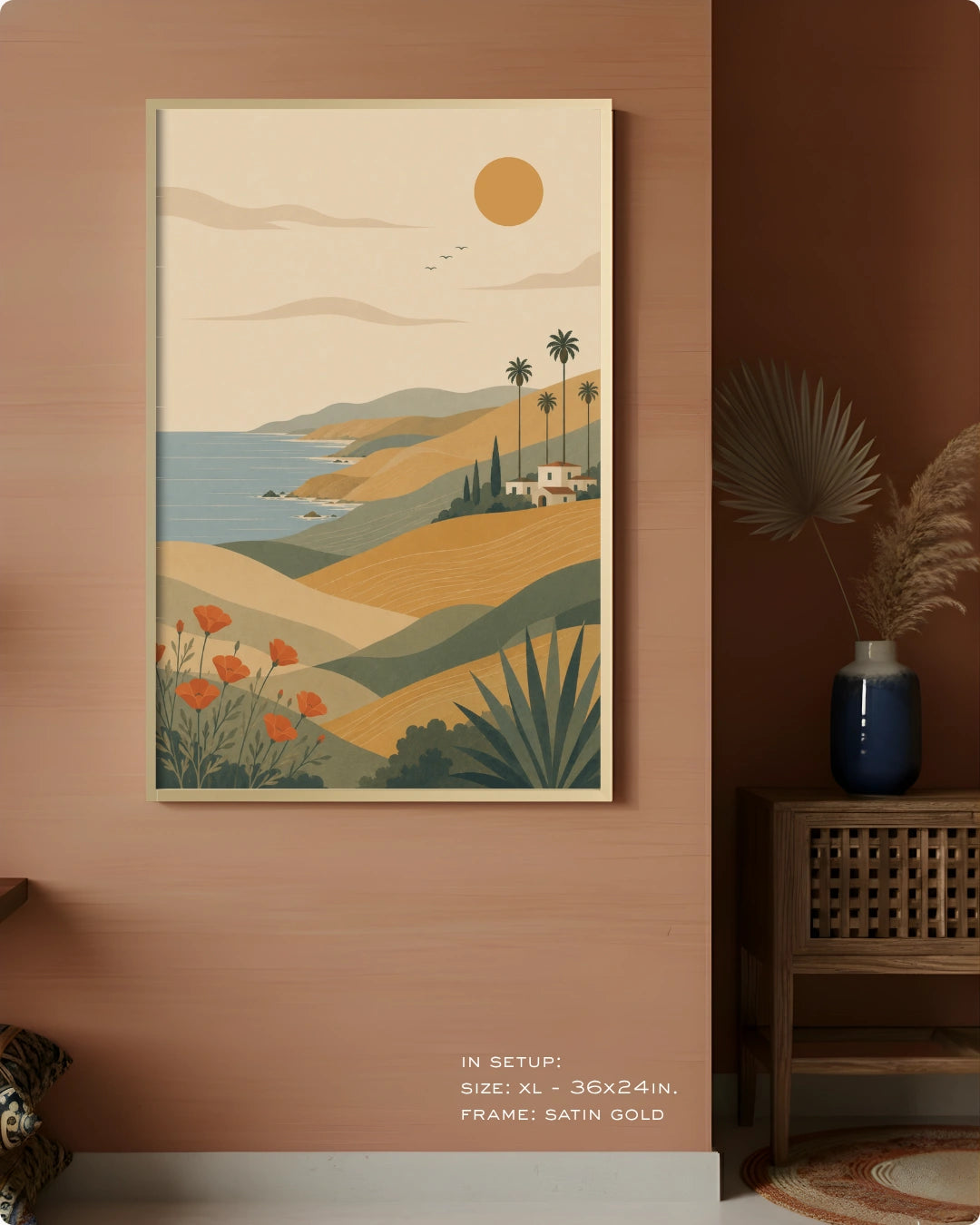 A framed art print depicting a retro-style coastal landscape with rolling hills, palm trees, a blue sea, and a sun, displayed on a warm terracotta wall in a styled interior setting.