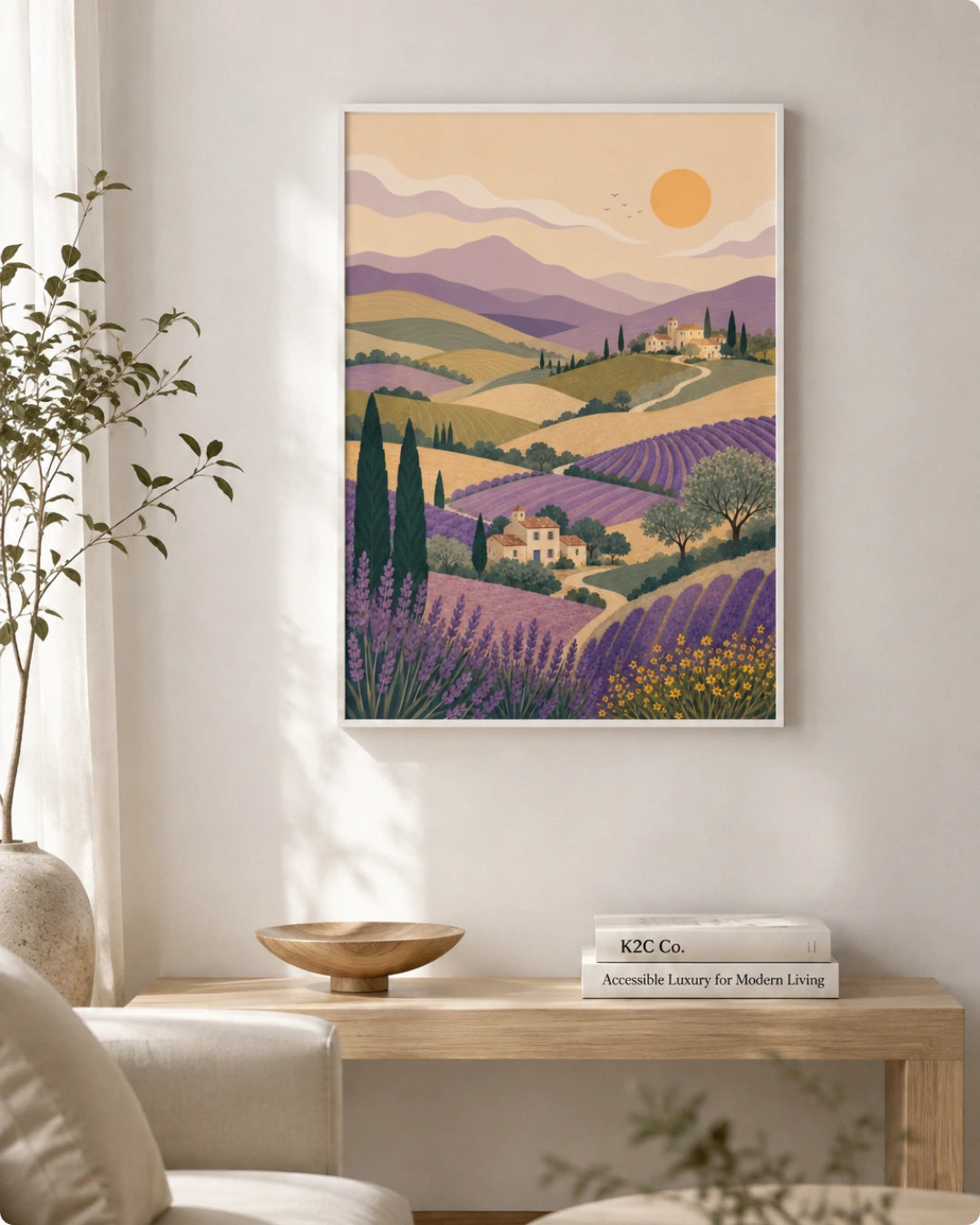 A framed art print depicting a stylized Provence landscape with lavender fields, mountains, and a sun, displayed on a light wall above a wooden console table in a modern living room setting.
