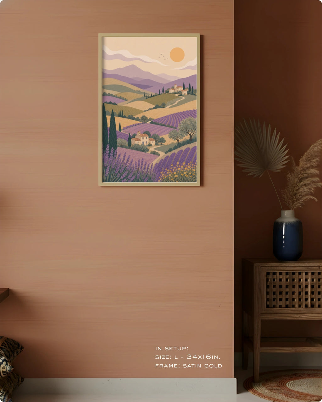 A framed art print depicting a stylized lavender field landscape with purple hills, distant mountains, and a yellow sun, displayed on a warm terracotta wall in a styled interior setting.