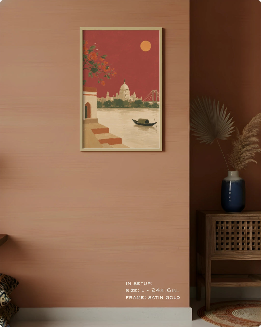 A framed art print featuring a retro-style illustration of a river scene with a domed building, boat, and red sky, displayed on a peach-colored wall in a styled interior setting.