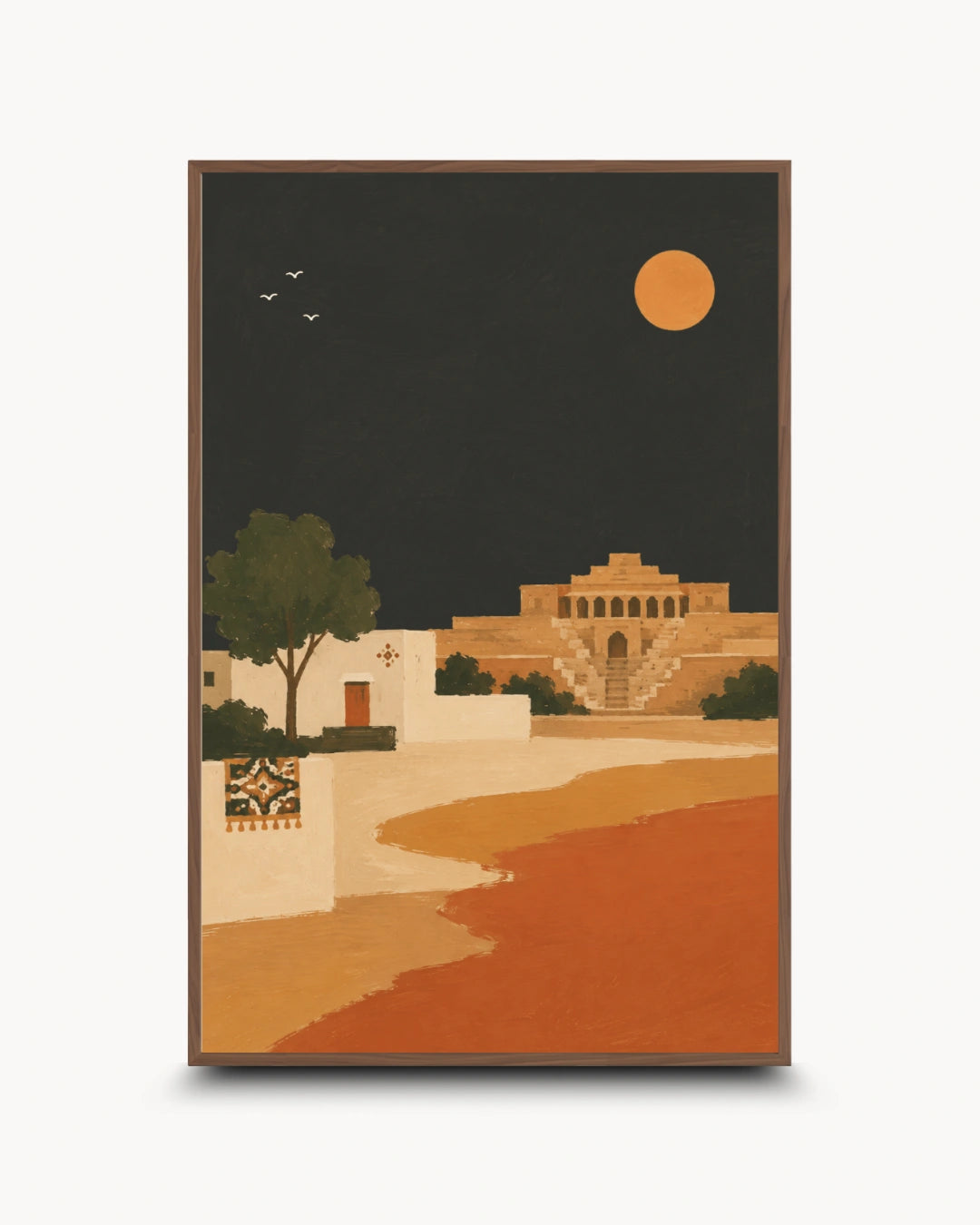 A framed art print featuring a stylized desert landscape at night, with a large orange moon, a dark sky, tan buildings, a tree, and a winding orange path, shown against a light gray background.