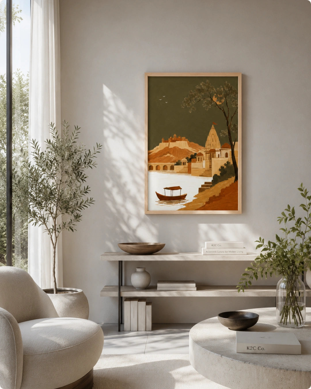 A framed art print depicting a stylized landscape with a boat on water and a tower, displayed on a light gray wall in a modern, sunlit living room with a chair, console shelf, and plants.