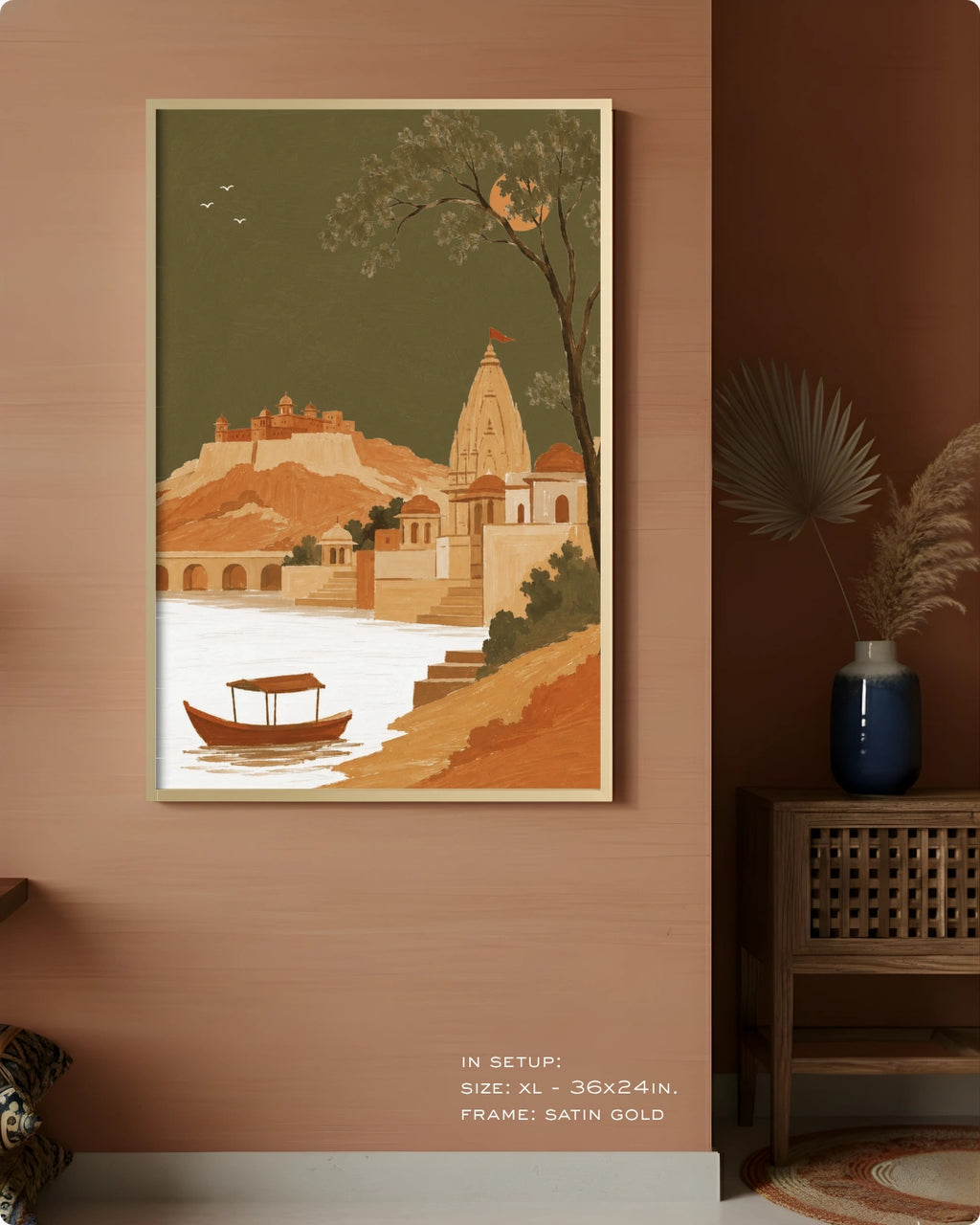A framed art print depicting a traditional Indian architectural scene with a temple, fort, boat, and river, displayed on a warm terracotta wall in a styled interior setting.