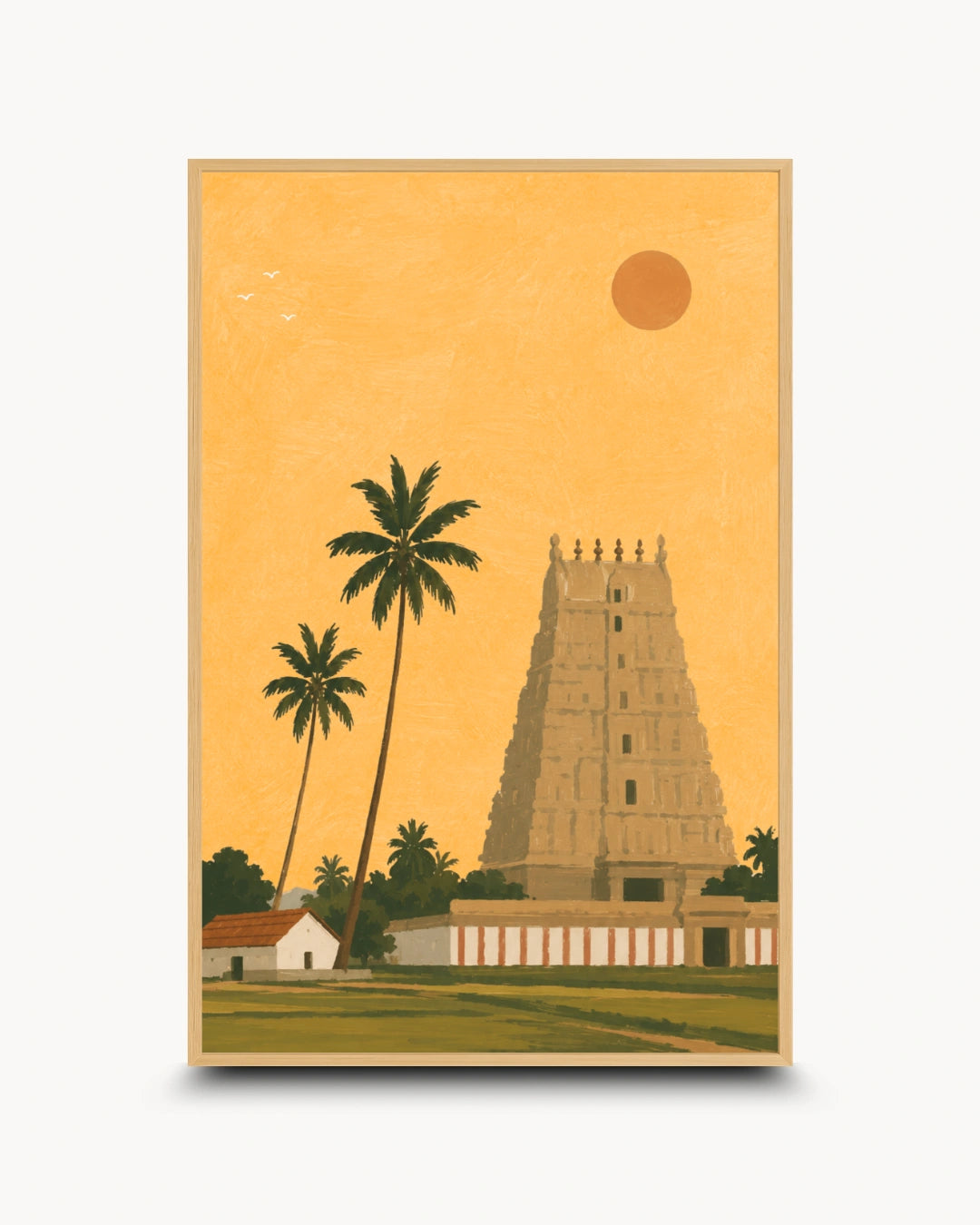 A framed art print featuring a stylized illustration of a South Indian temple tower, palm trees, a small house, and a sun against a warm golden-yellow sky, shown on a light gray background.