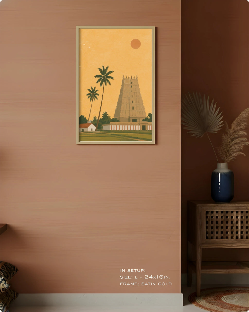 A framed art print depicting a traditional South Indian temple tower and palm trees, styled on a terracotta-colored wall in a modern interior setting.