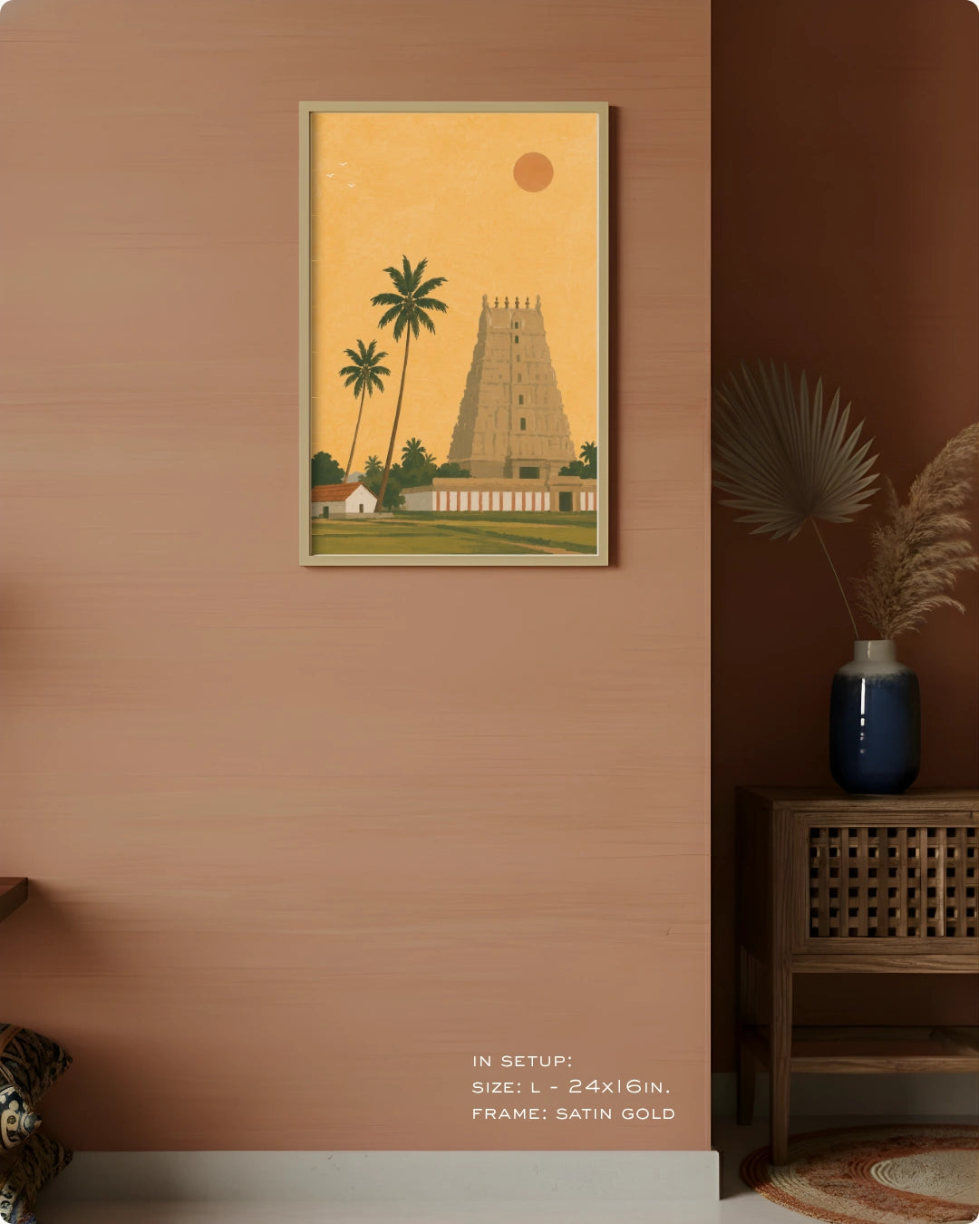A framed art print depicting a traditional South Indian temple tower and palm trees, styled on a terracotta-colored wall in a modern interior setting.