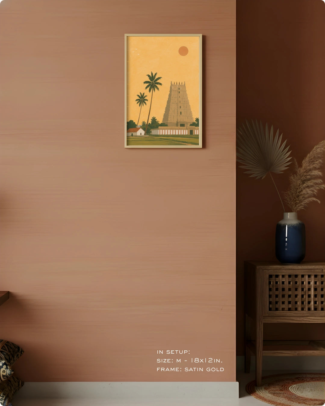 A framed art print depicting a traditional South Indian temple tower and palm trees, styled on a terracotta-colored wall in a modern interior setting.