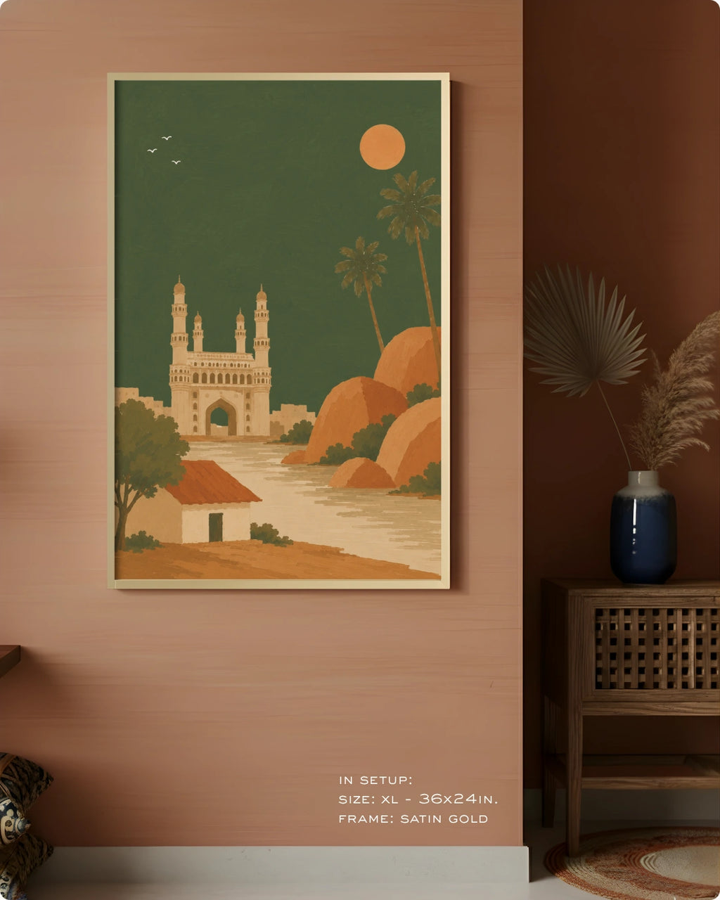 A framed art print depicting a retro-style Indian landscape with the Charminar tower, palm trees, and a sun in a dark green sky, displayed on a terracotta-colored wall in a styled room setting.
