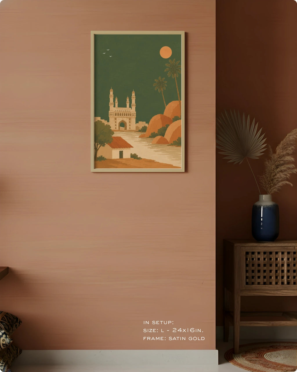 A framed art print featuring a retro-style illustration of a cathedral and desert landscape, displayed on a terracotta-colored wall in a styled interior setting.