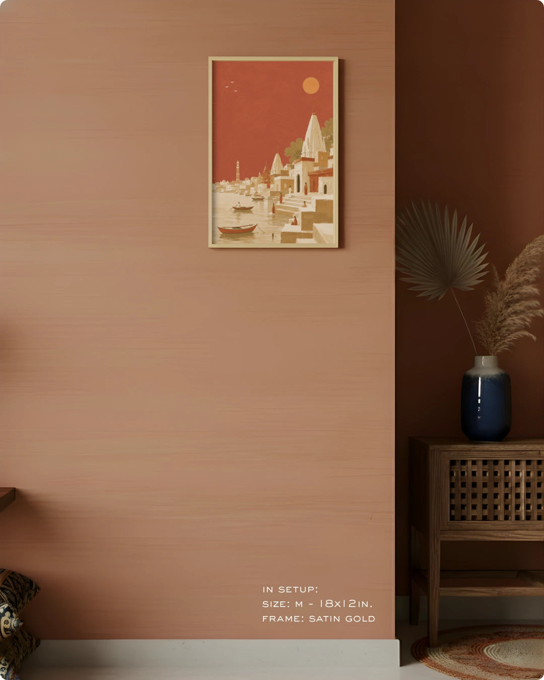 A framed art print featuring a retro-style coastal cityscape in terracotta red, beige, and cream, displayed on a textured terracotta wall in a styled interior setting.