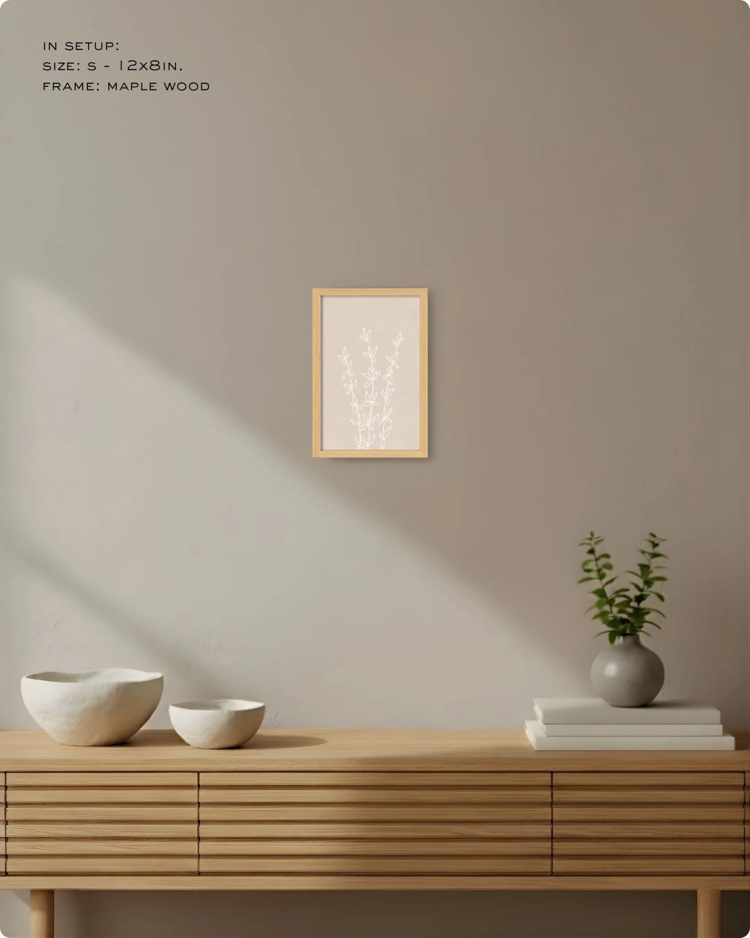 Large (Size L) Essence botanical line art by K2C Co. in a Maple Wood frame, styled above a slatted light wood sideboard with soft sunlight shadows for an organic modern look.