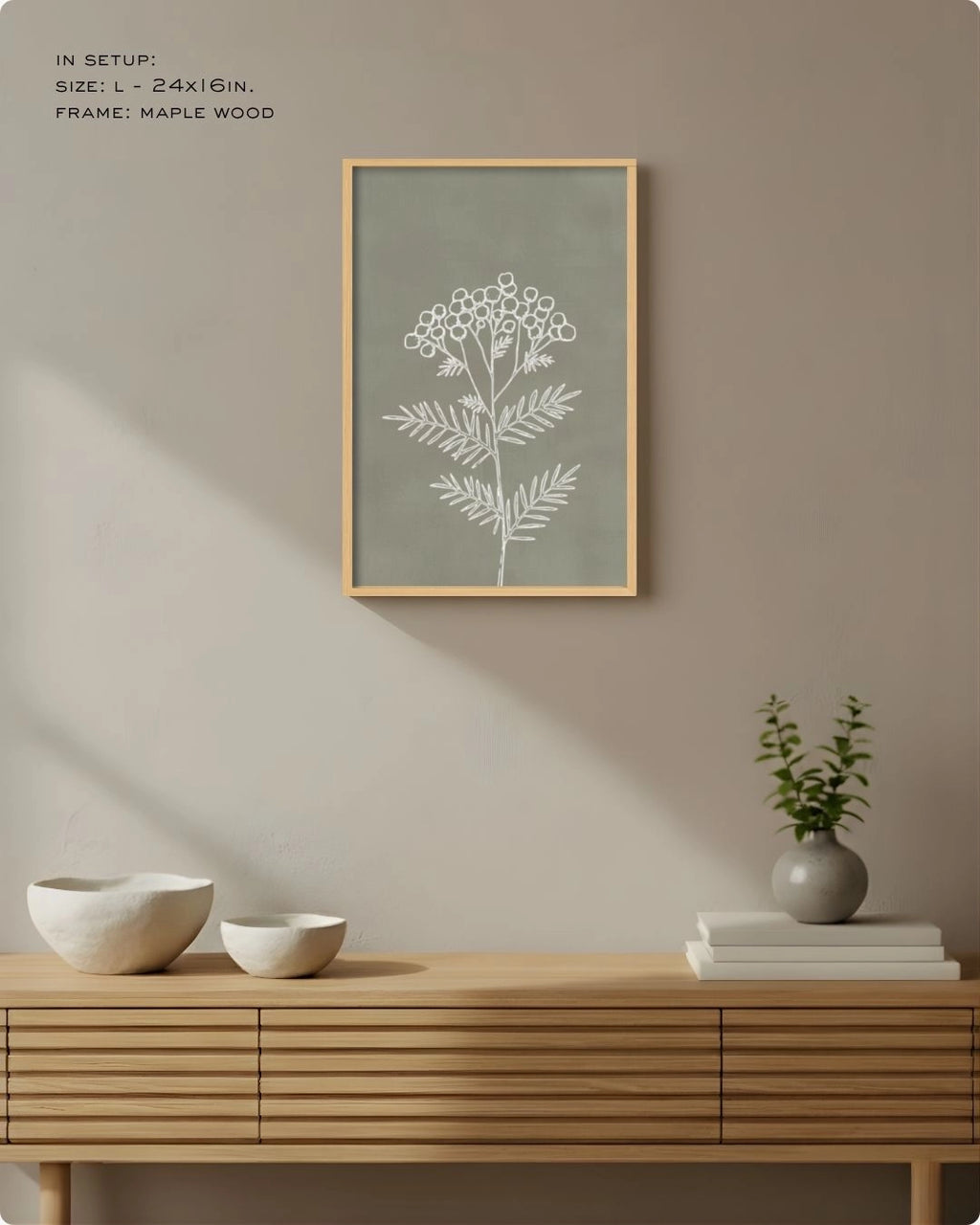 Large (Size L) sage green botanical line art in a Maple Wood frame, styled above a slatted sideboard with soft sunlight shadows.