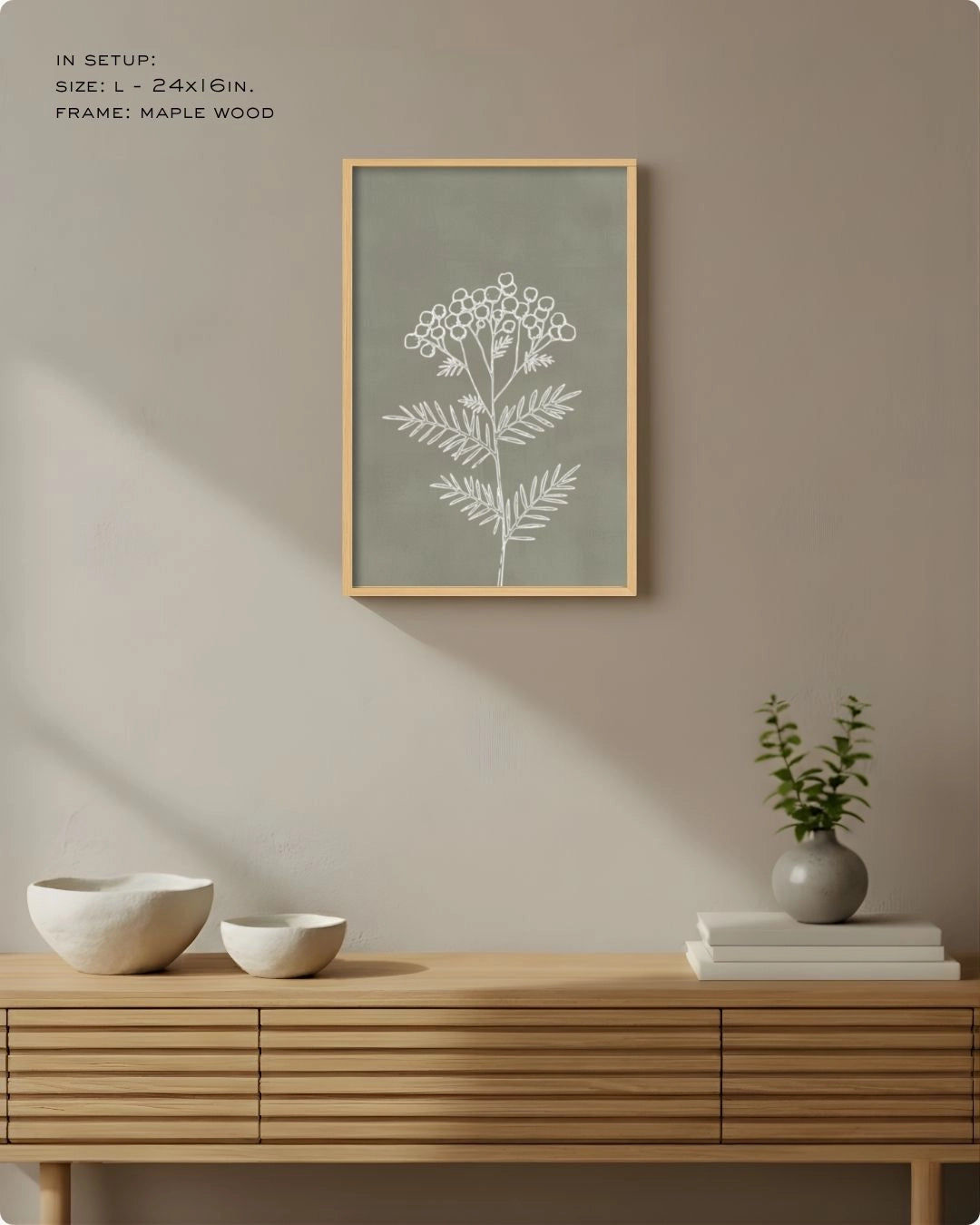 Large (Size L) sage green botanical line art in a Maple Wood frame, styled above a slatted sideboard with soft sunlight shadows.
