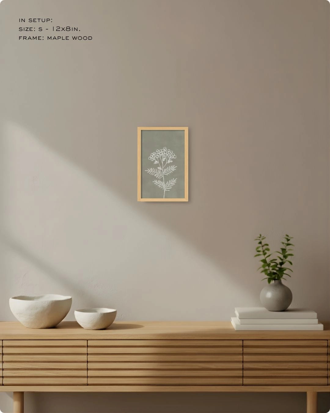 Small (Size S) sage green botanical accent print in a natural Maple Wood frame, demonstrating small-space styling on a neutral wall.