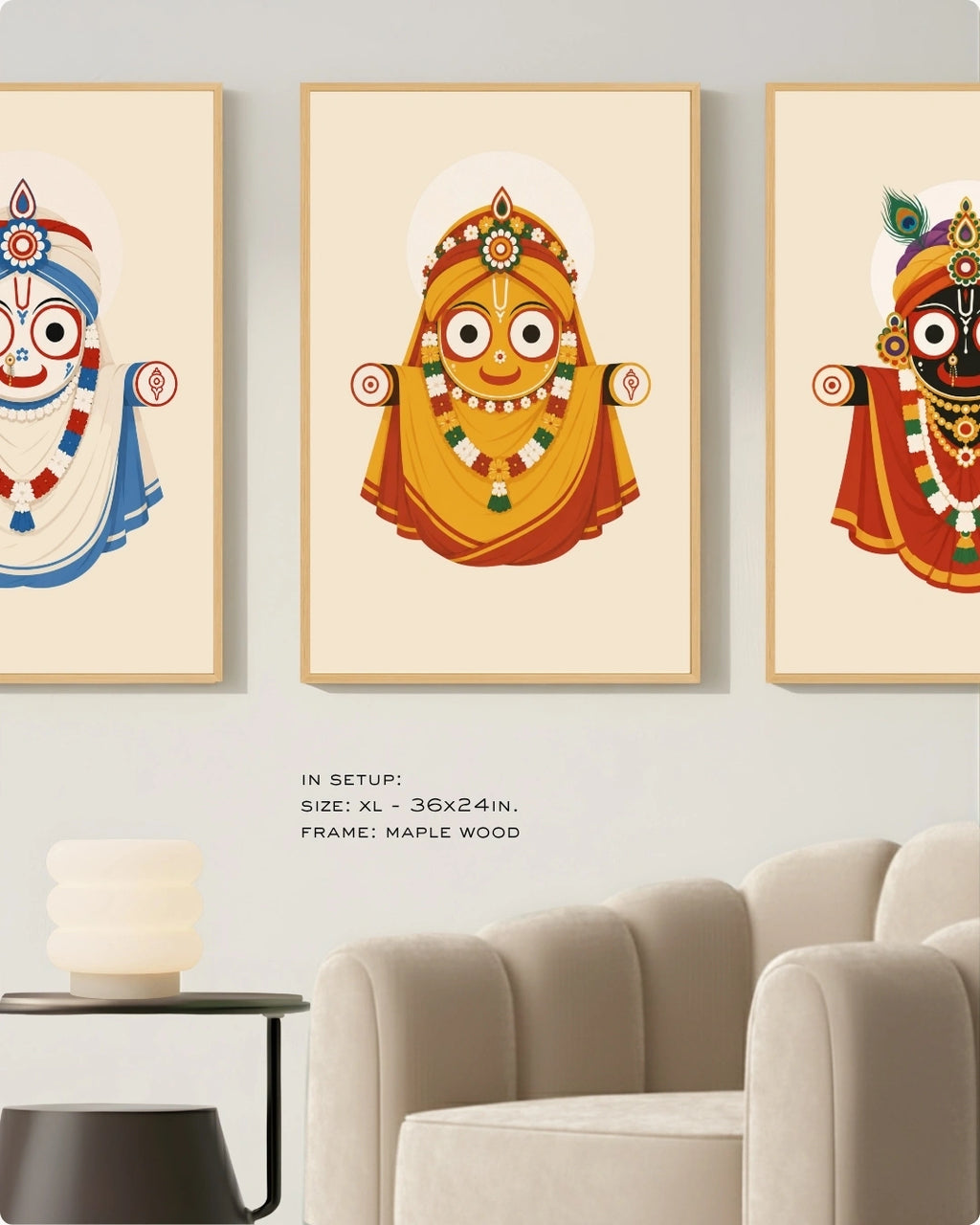 Visual size guide mockup for the Jagannath Triad 3 piece wall art set in Extra Large size with satin gold frames displayed above a modern ribbed beige armchair.