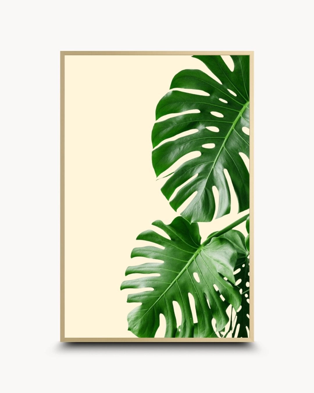 K2C Co. minimalist botanical Monstera leaf artwork in an elegant Satin Gold frame. Features vibrant green tropical leaves on a neutral cream background for a luxury modern wall decor look.